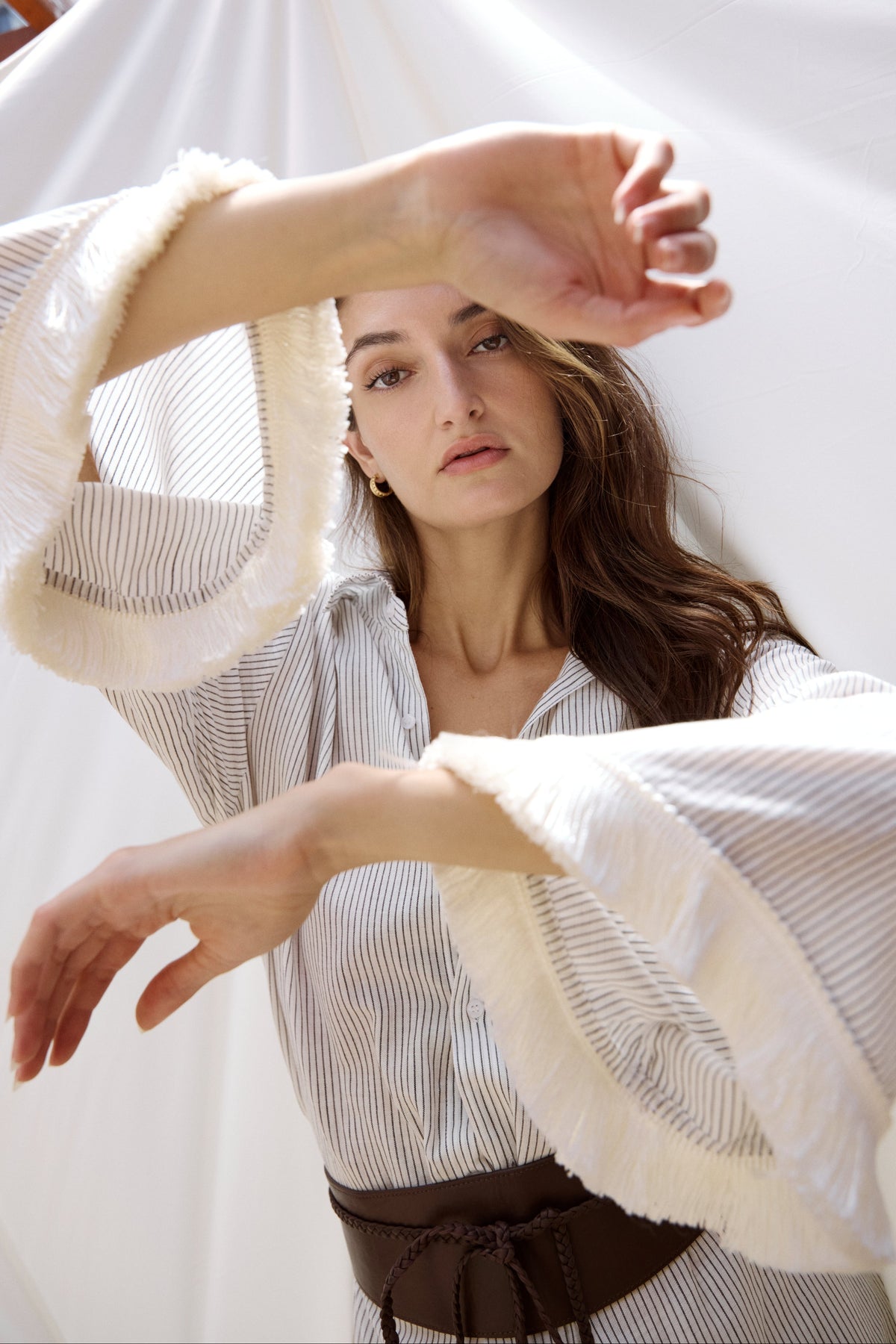 Model wearing the Zandra Stone Isola Fringe Shirt - Stripe with the Baxter Leather Wrap Belt.